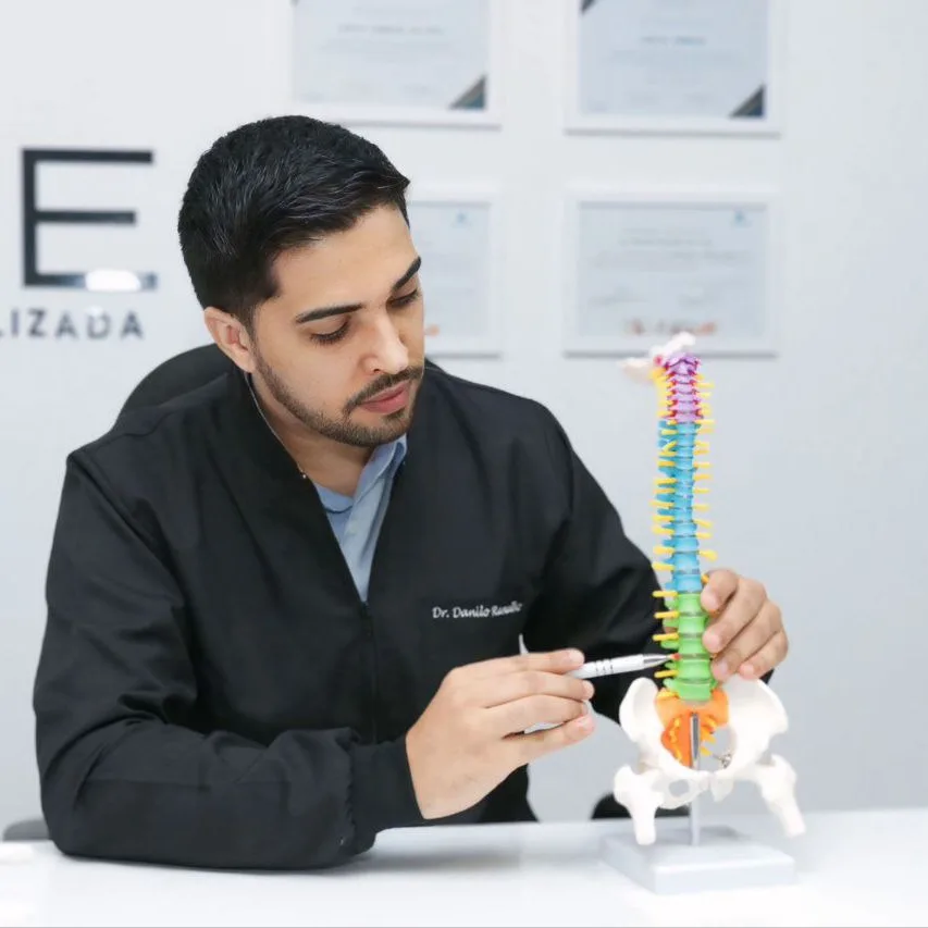 Dr. Danilo Ramalho explicando a coluna vertebral em um modelo anatômico