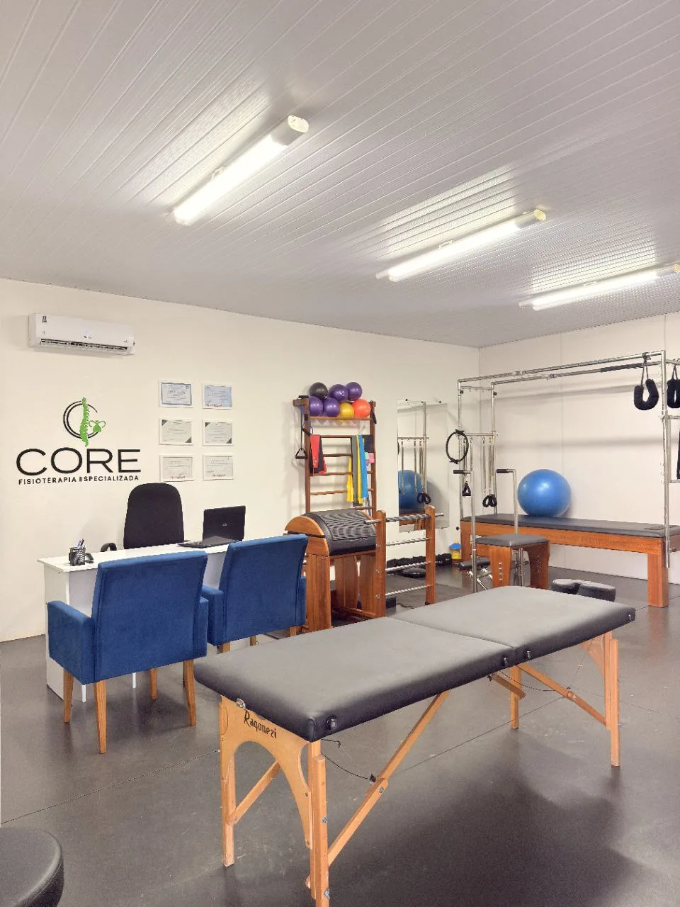 Sala de atendimento da CORE Fisioterapia com maca e aparelhos de pilates